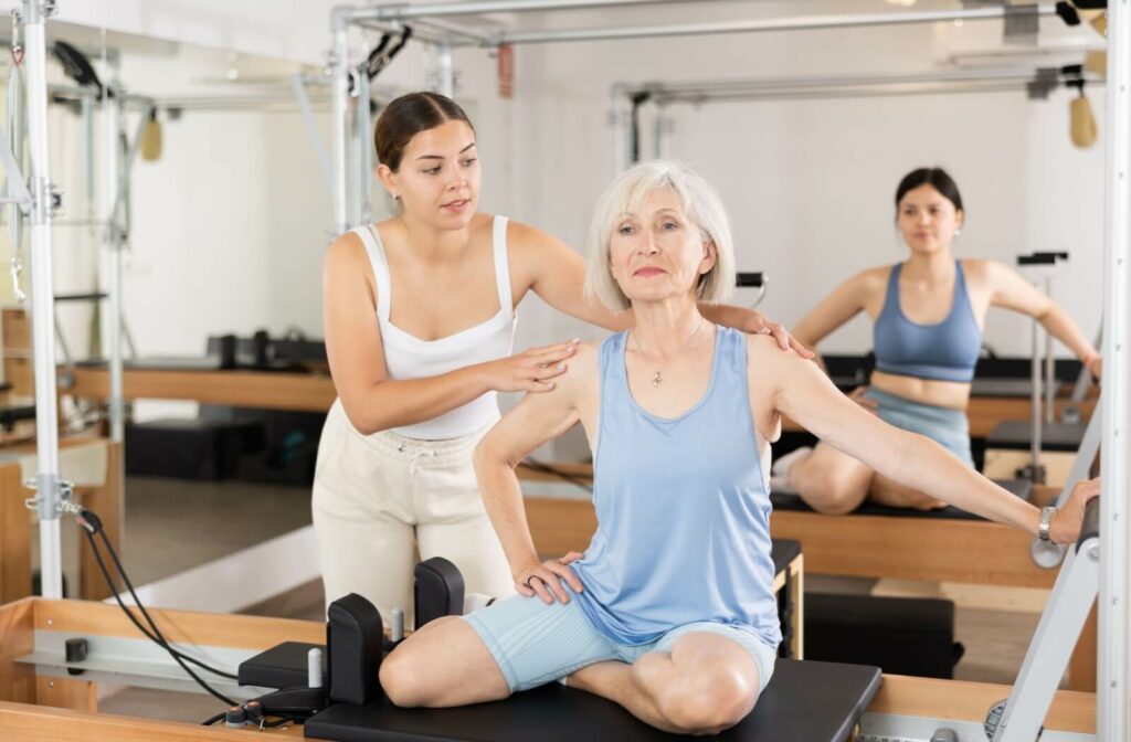 An older adult focuses on improving hip mobility and flexibility during a pilates session.