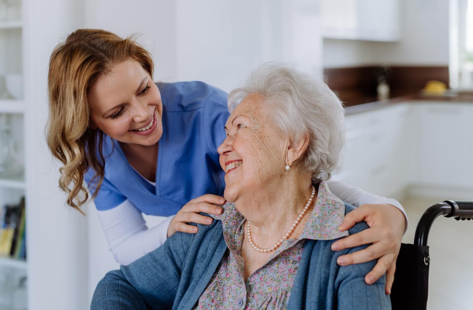 A caregiver checks in with a happy respite care resident.
